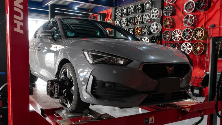 auto en taller durante revisión de frenos llantas y alineación